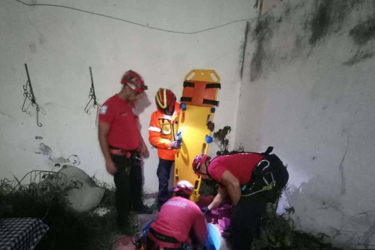 Bomberos rescatando a una anciana que se cayó en un pozo.